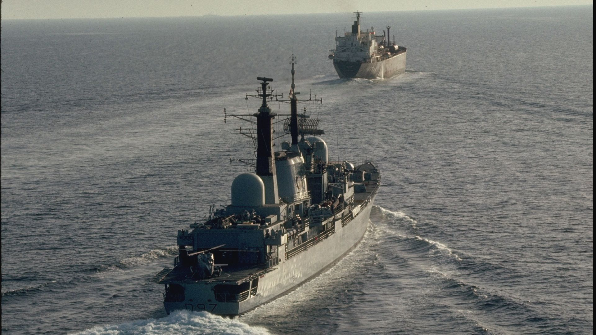 British destroyer Edinburgh escorting prob. British oil tanker through Iran-Iraq tanker war plagued waters, heading for Strait of Hormuz in Gulf of Oman.