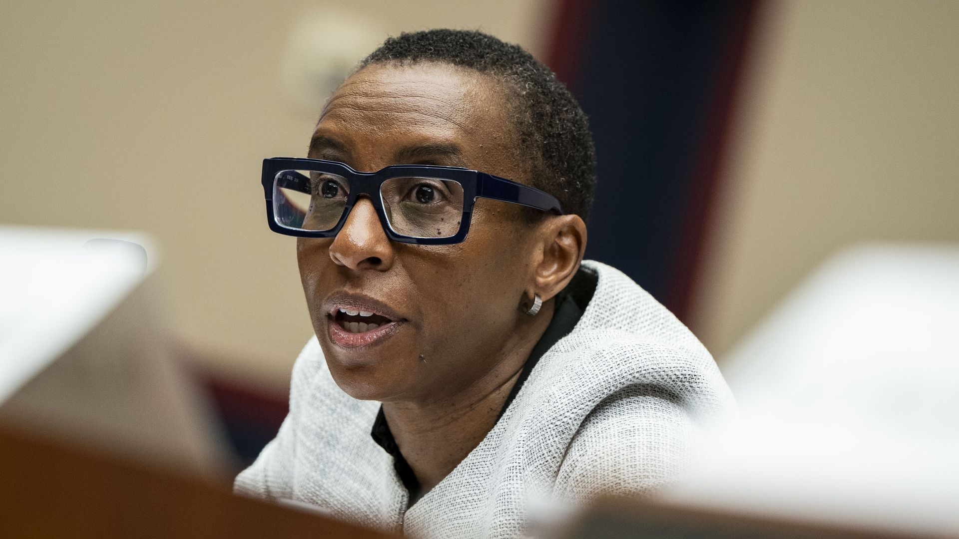 A photo of Claudine Gay taken from the side. She is wearing a gray blazer and dark glasses and speaking.