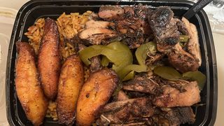 Spicy jerk chicken and jollof rice with sweet plantains. Photo: Samuel Robinson/Axios