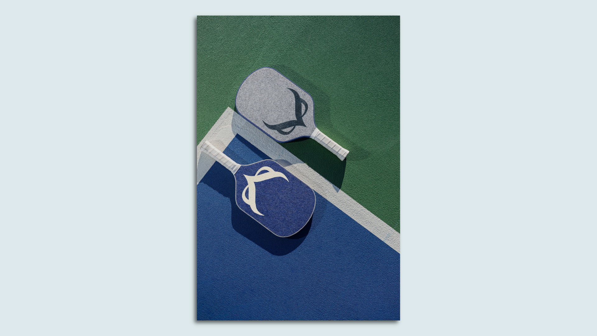Two pickleball paddles laid out on a playing court.