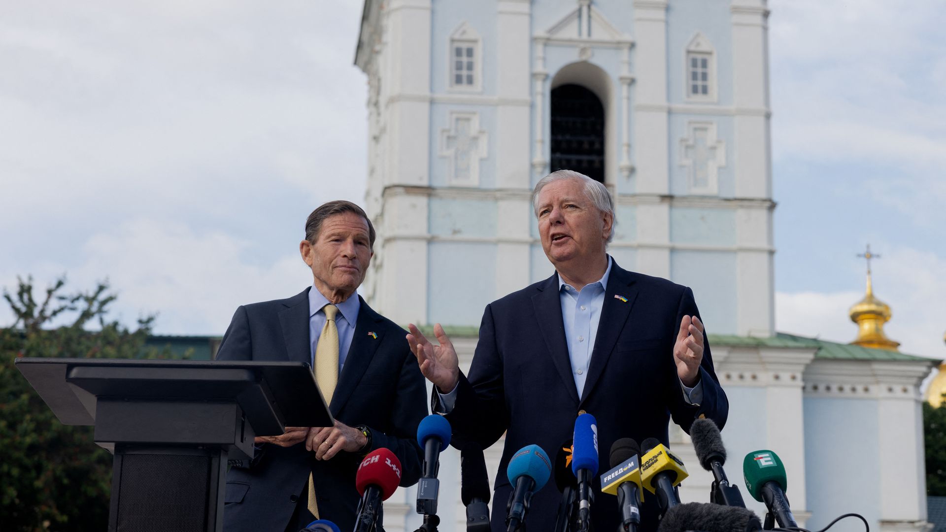 Two senators stand before a church in Ukraine