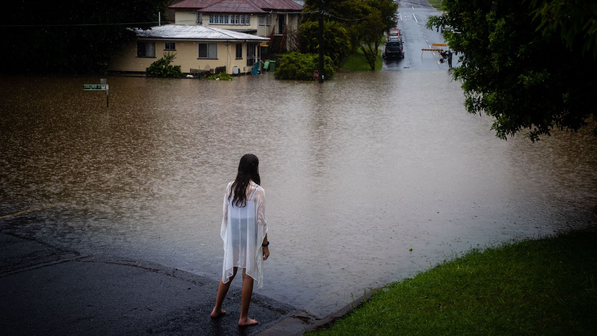 A woman looks at rising waters in Queensland, Australia.