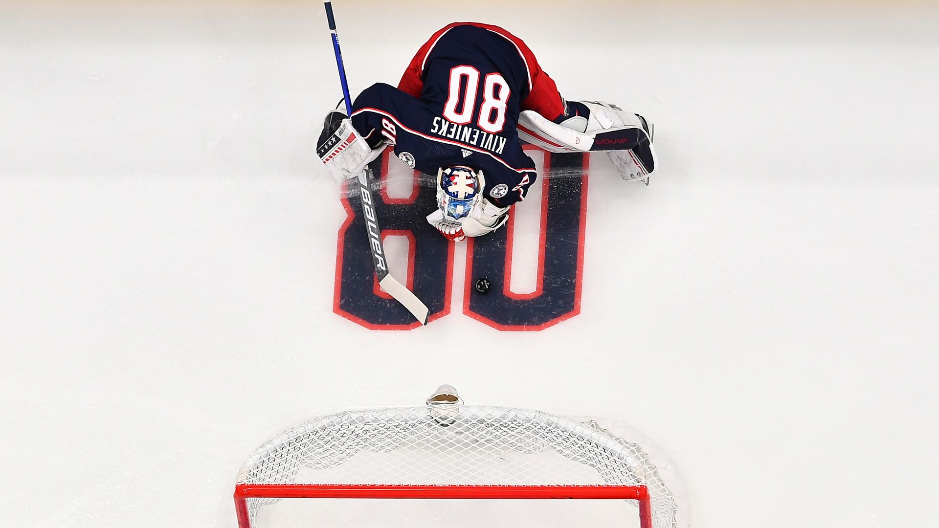 A goaltender wearing the jersey of a late teammate is seen on the ice.