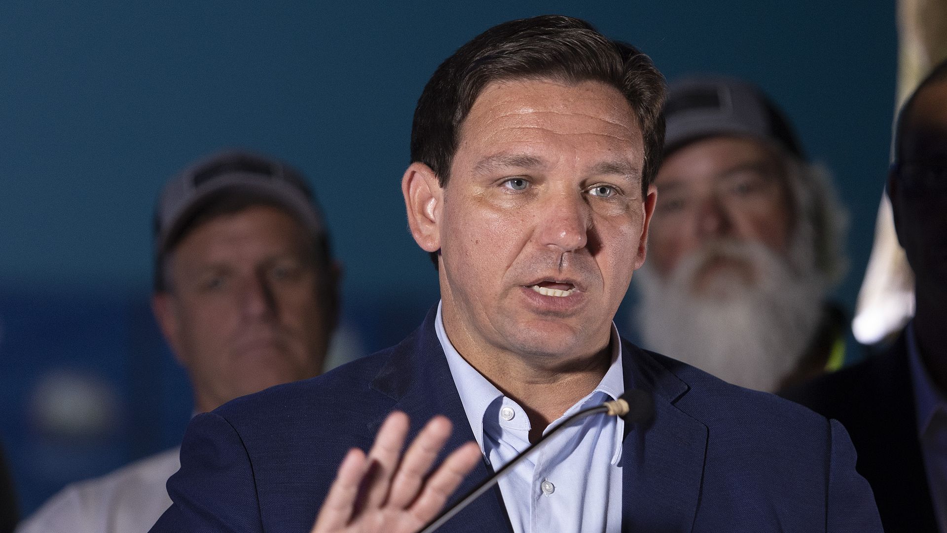 Photo of Ron DeSantis speaking from a podium while gesturing with his right hand