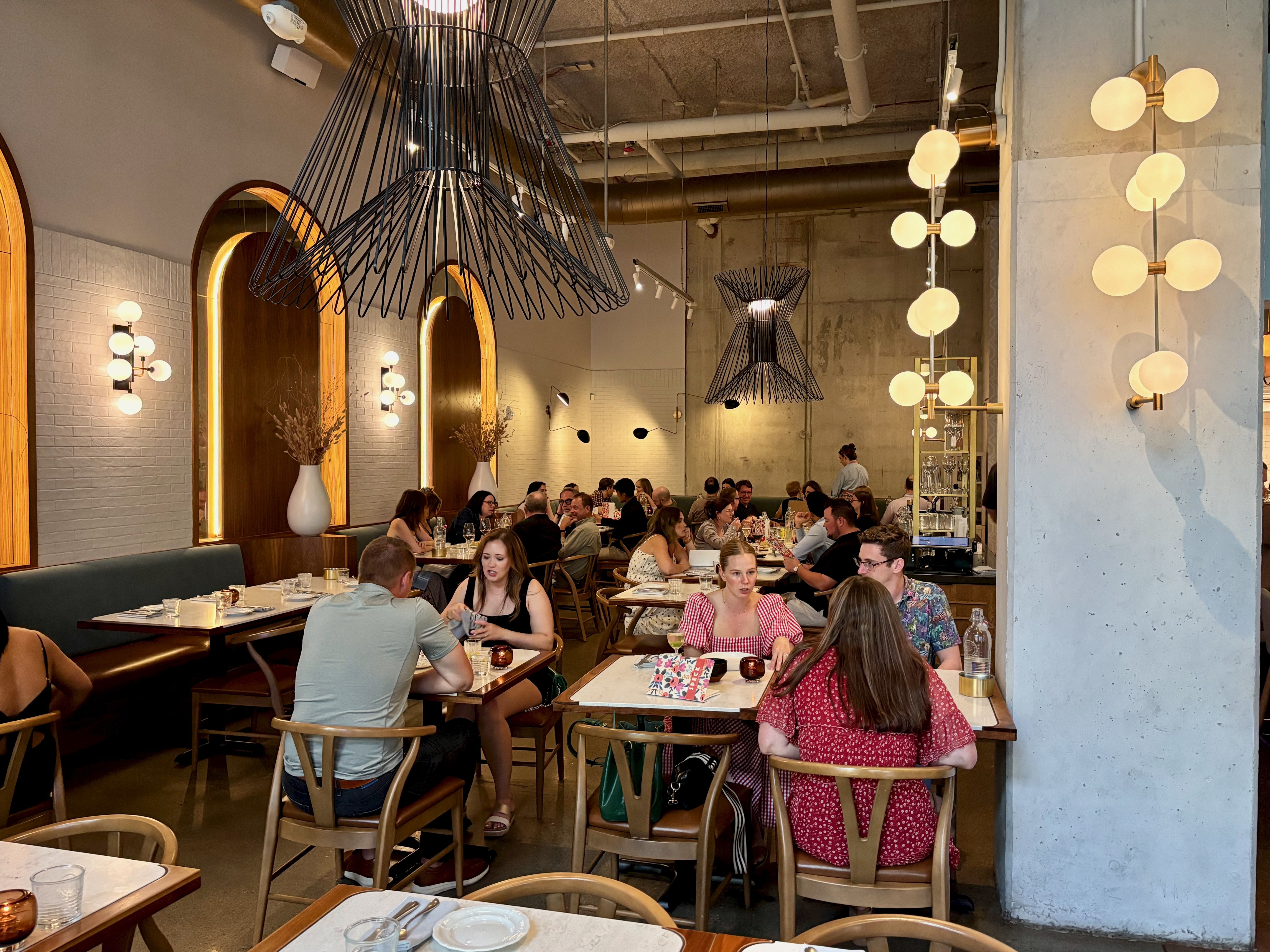 The interior of Speck, with lots of unique, modern lighting and full tables