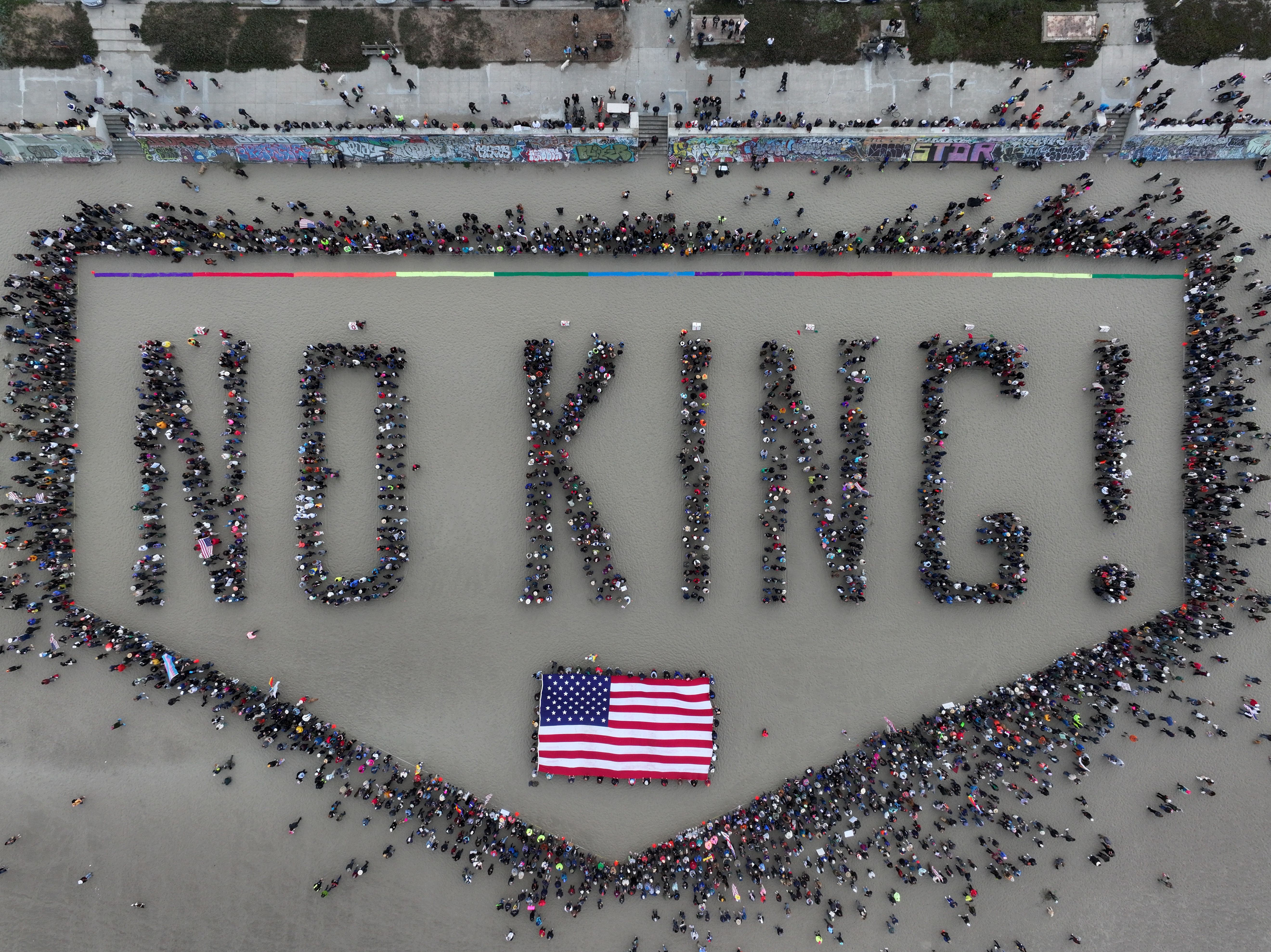 People arrange themselves to spell "No King!" when seen from above