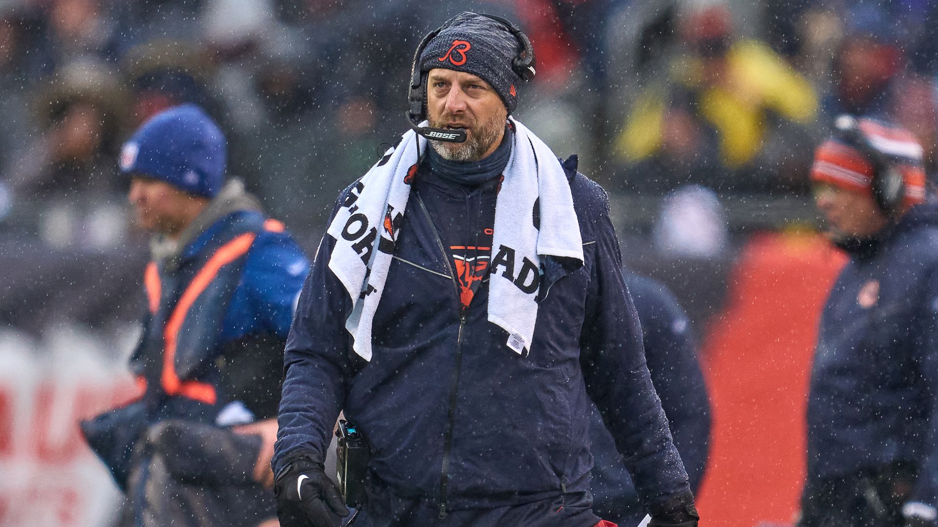 A photo of a coach on the sidelines of a football game. 