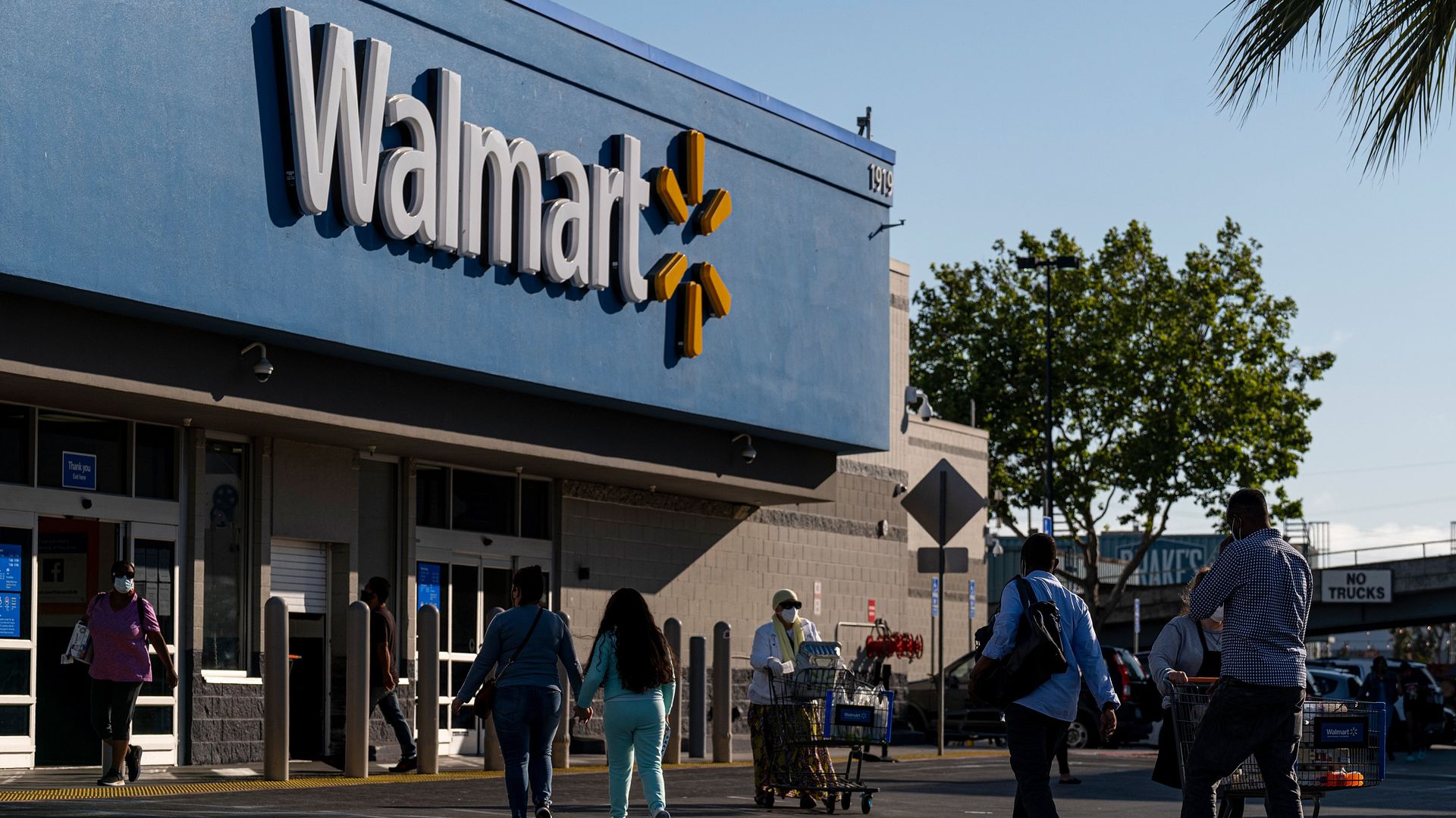 Shoppers walk in front of a Walmart store in San Leandro, California in May.