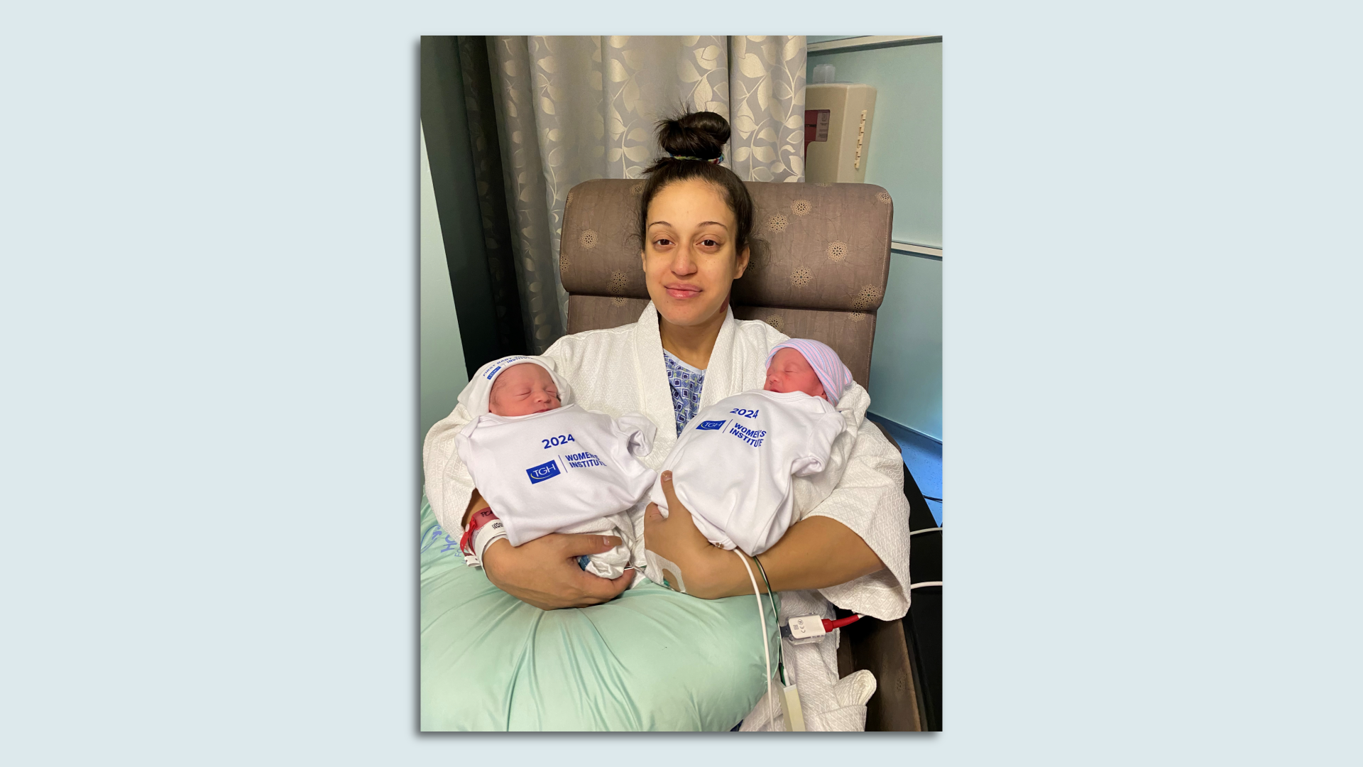 A mother holds twin babies born on New Year's day. 