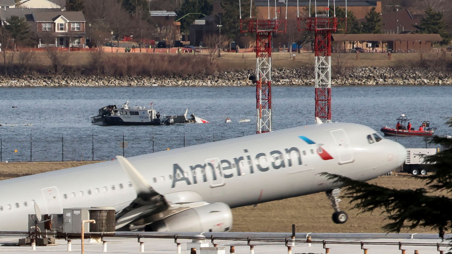 Một chiếc máy bay của American Airlines cất cánh từ Sân bay quốc gia Ronald Reagan Washington (DCA) khi các đội cứu hộ làm việc tại hiện trường vụ tai nạn trên sông Potomac sau khi một máy bay phản lực chở khách va chạm với một máy bay trực thăng khi hạ cánh tại Arlington, Virginia, Hoa Kỳ, vào thứ năm, ngày 30 tháng 1 năm 2025.