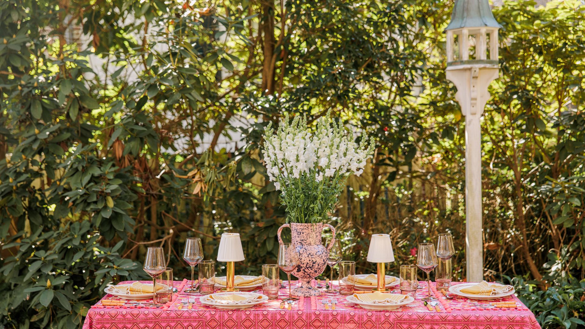 outdoor dinner party spread with hot pink tablecloth