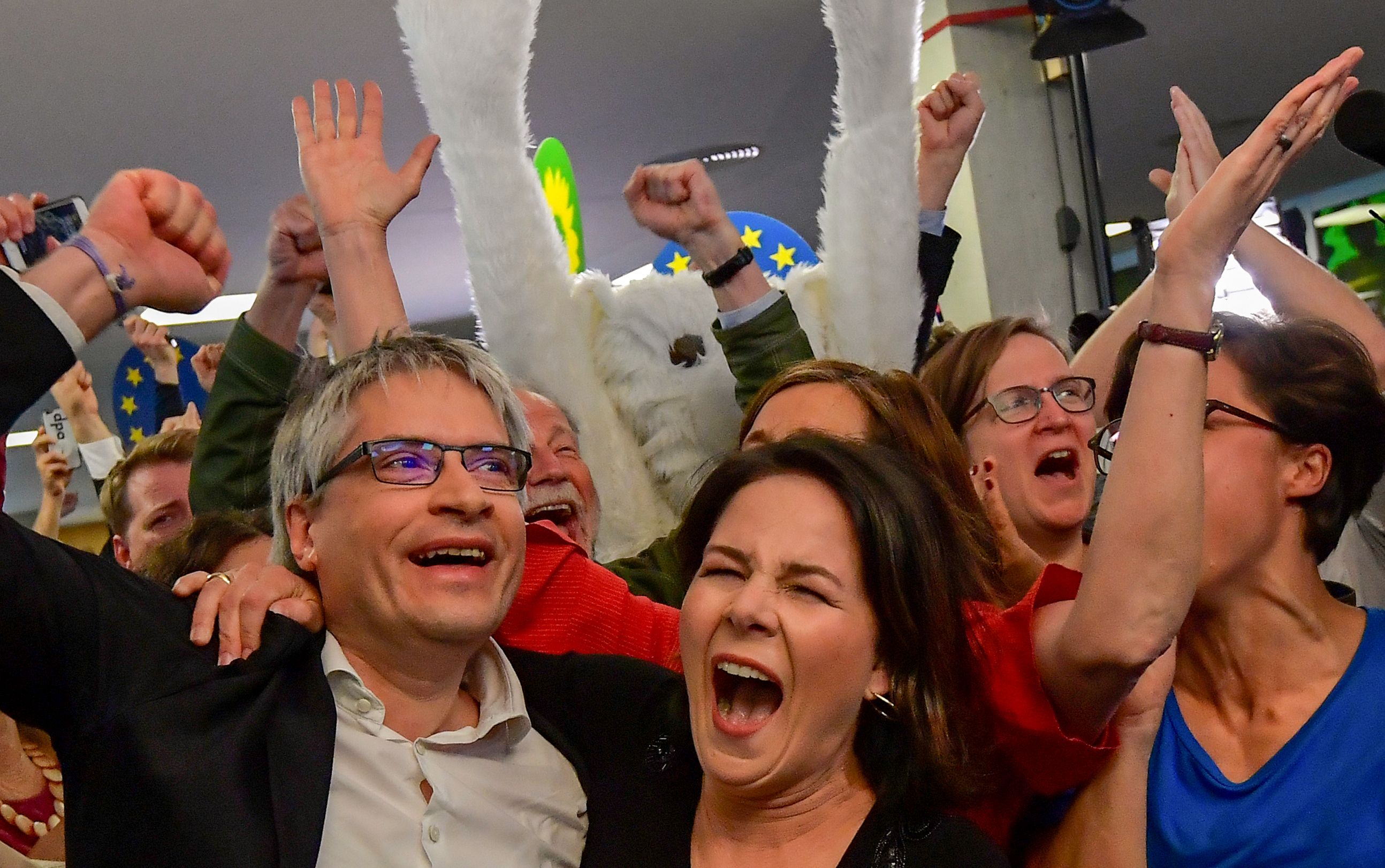 German Greens party top candidate Sven Giegold (L) and co-leader of the Green party Annalena Baerbock (C) celebrate as exit poll are announced on public broadcast TV stationsin Berlin.