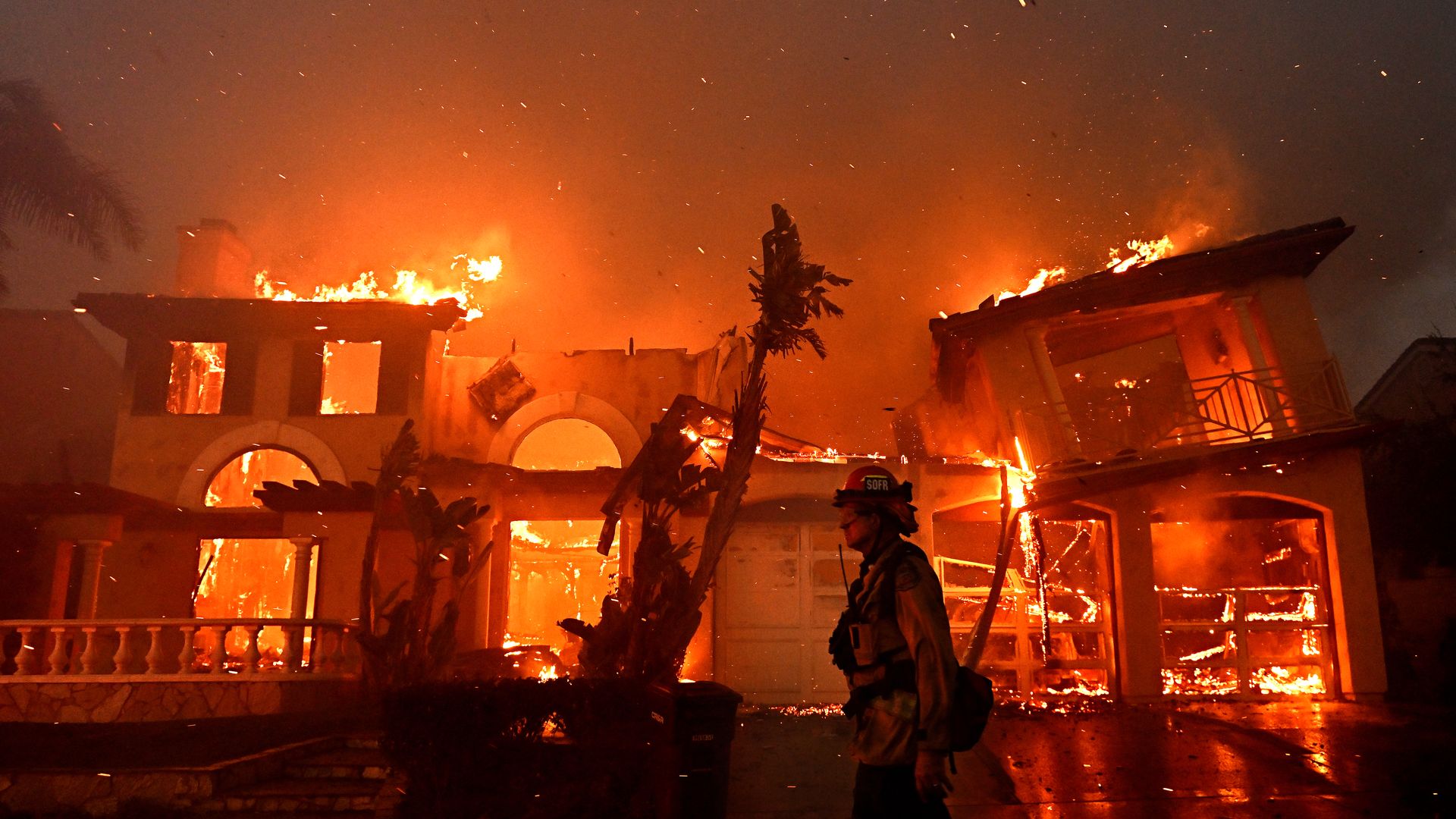 A wildfire burns down a home in a coastal area south of Los Angeles in May 2022.