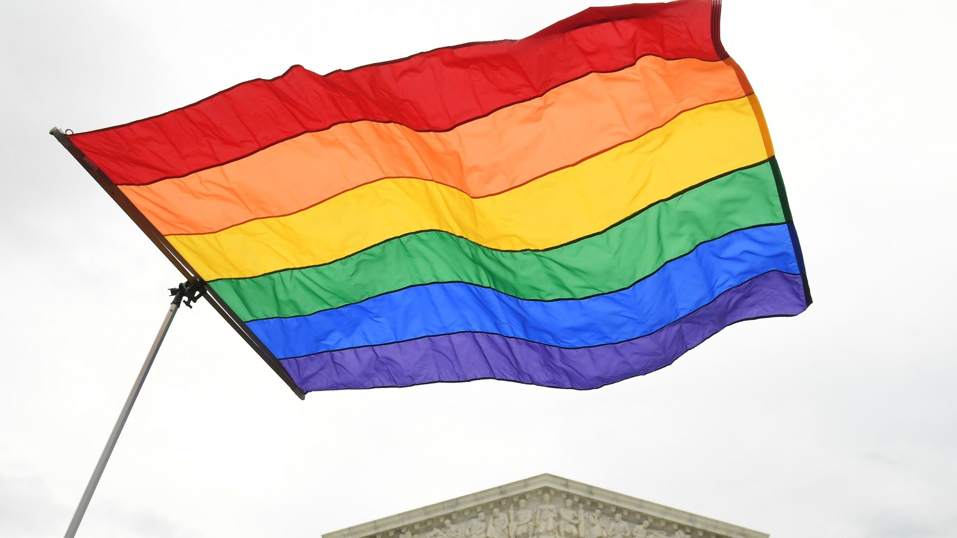 A pride flag waved in front of the U.S. Supreme Court 