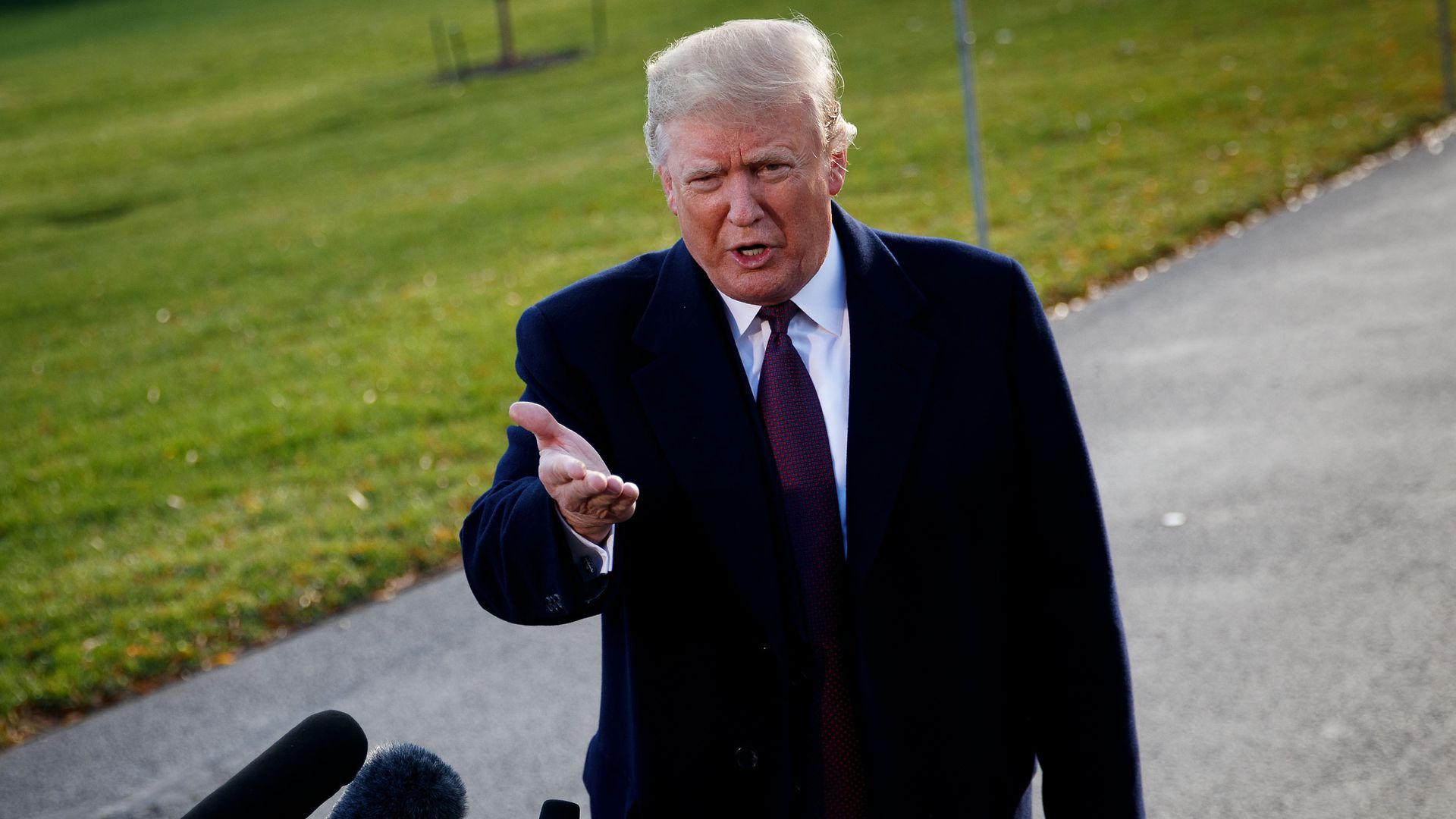 President Trump gestures with his right hand while speaking to reporters outside of the White House