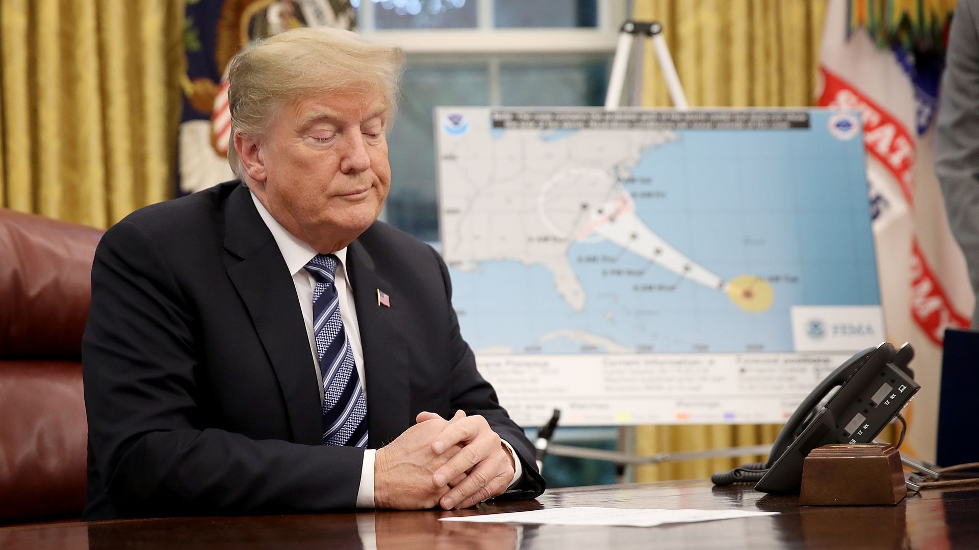 Trump sits as his desk during a meeting about Hurricane Florence