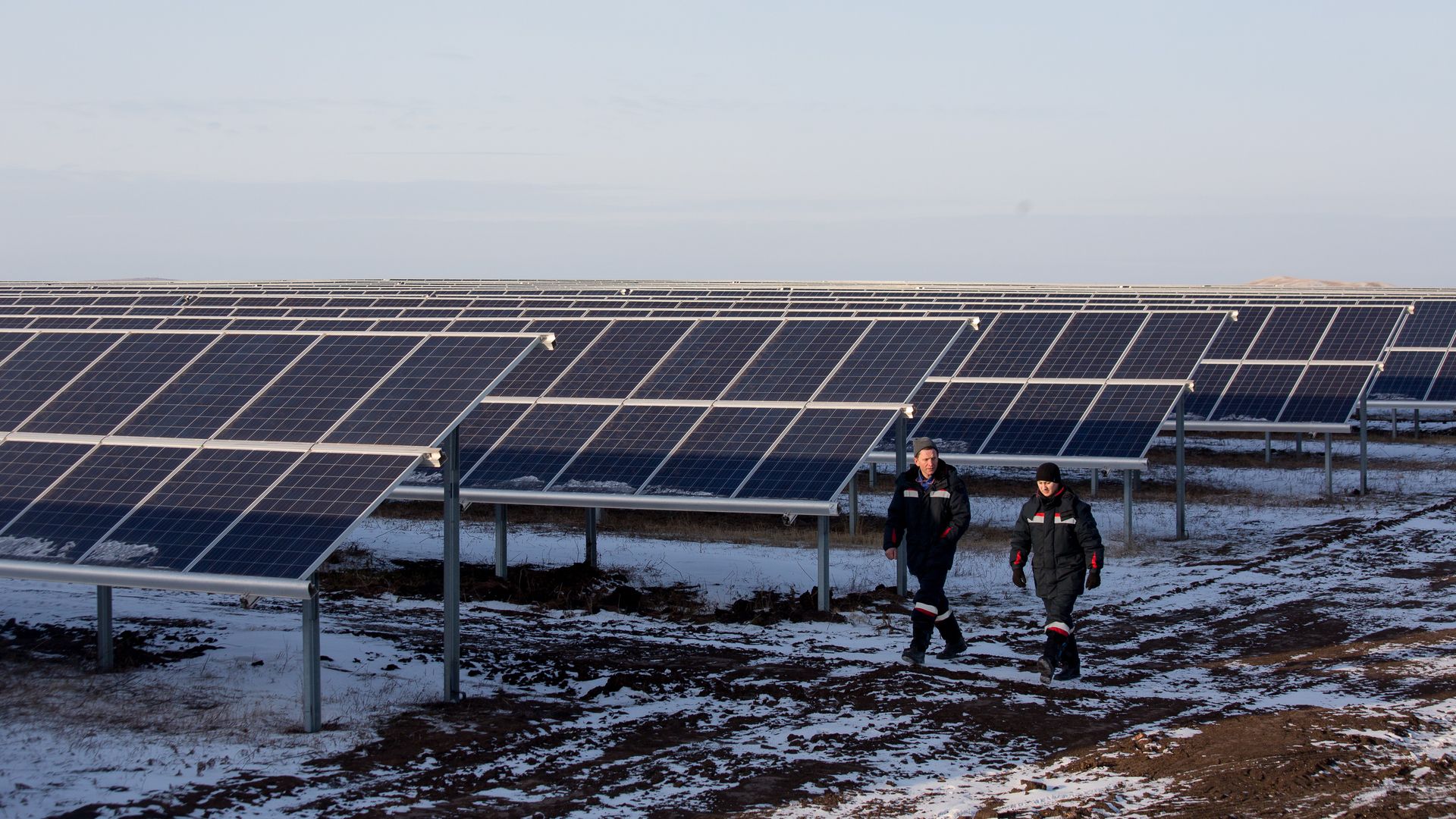Workers walking near solar panels