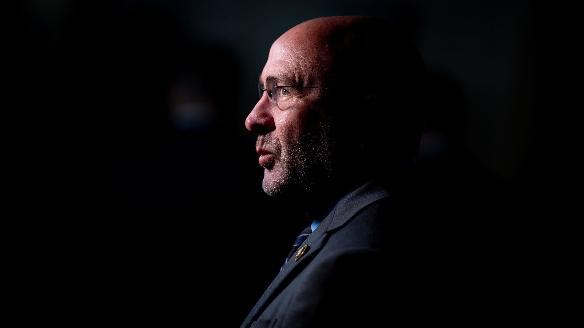 Rep. Clay Higgins, wearing a gray suit against a black backdrop.