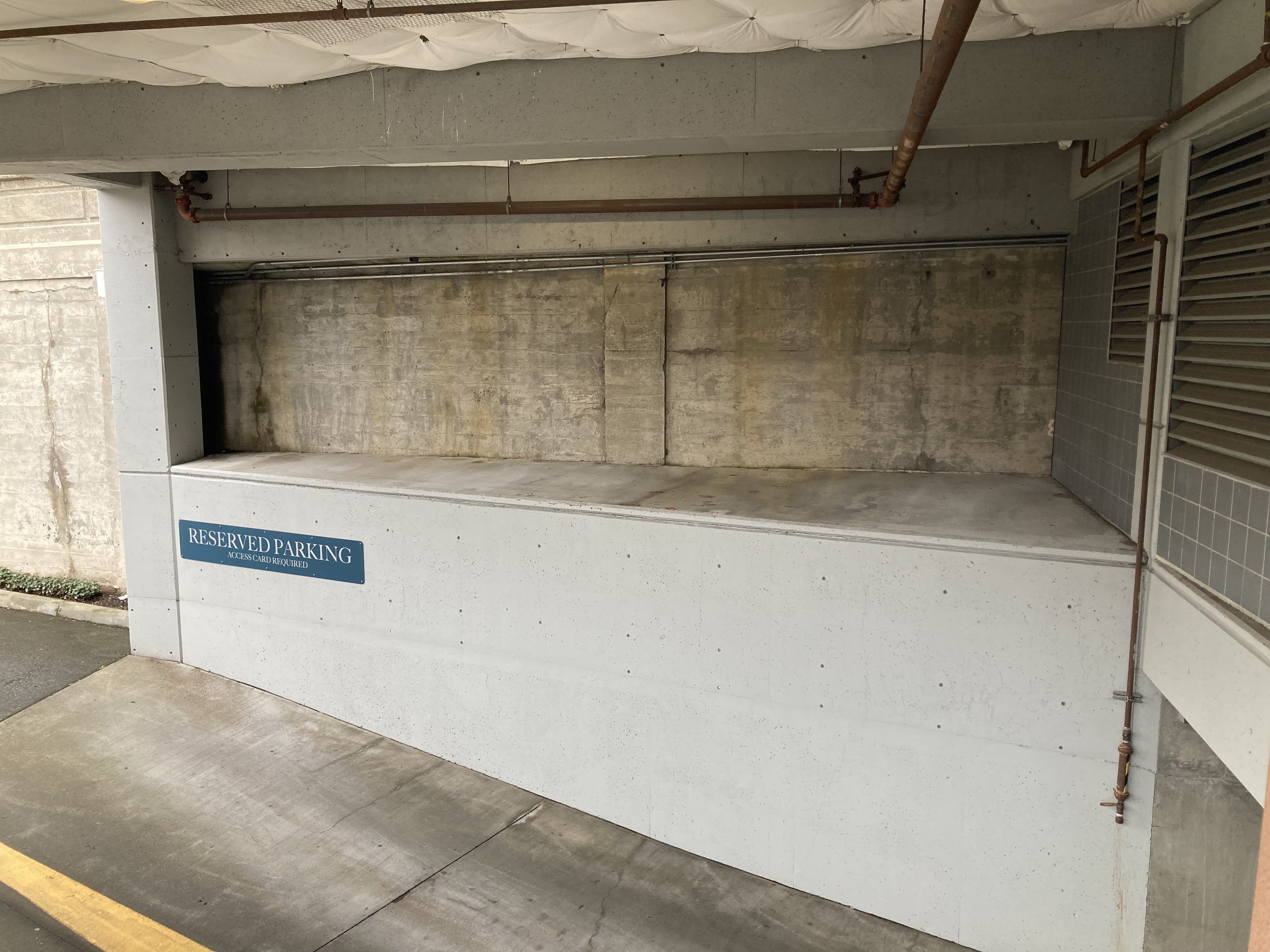 A concrete cubby hole at the entrance to a parking garage. 