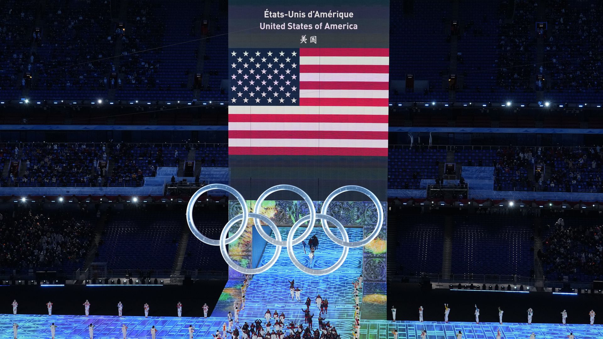 Flag bearers Brittany Bowe and John Shuster of Team United States carry their flag during the Opening Ceremony of the Beijing 2022 Winter Olympics