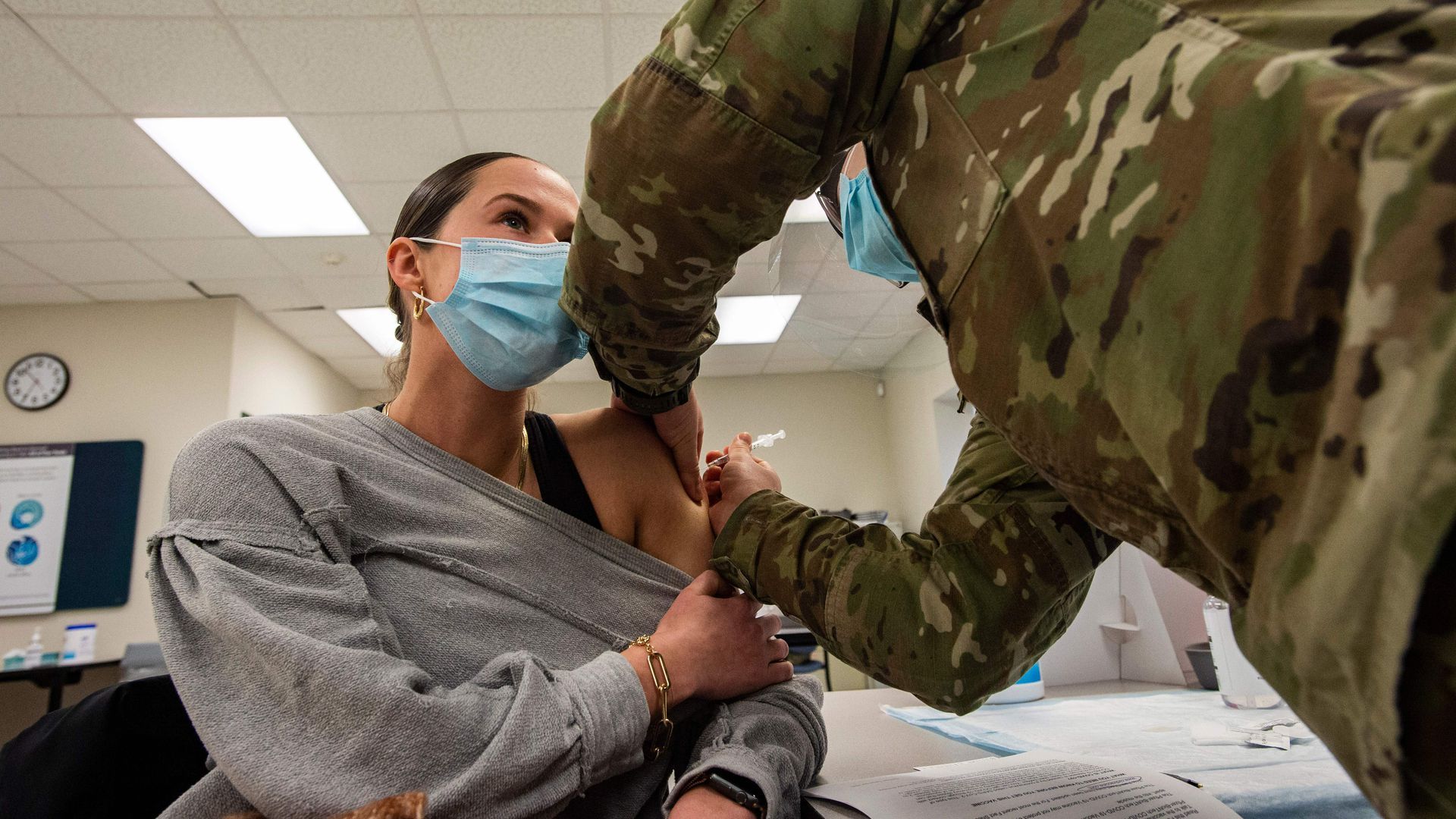 A woman receives a COVID-19 vaccine from a U.S. service member in Boston on Feb. 16.