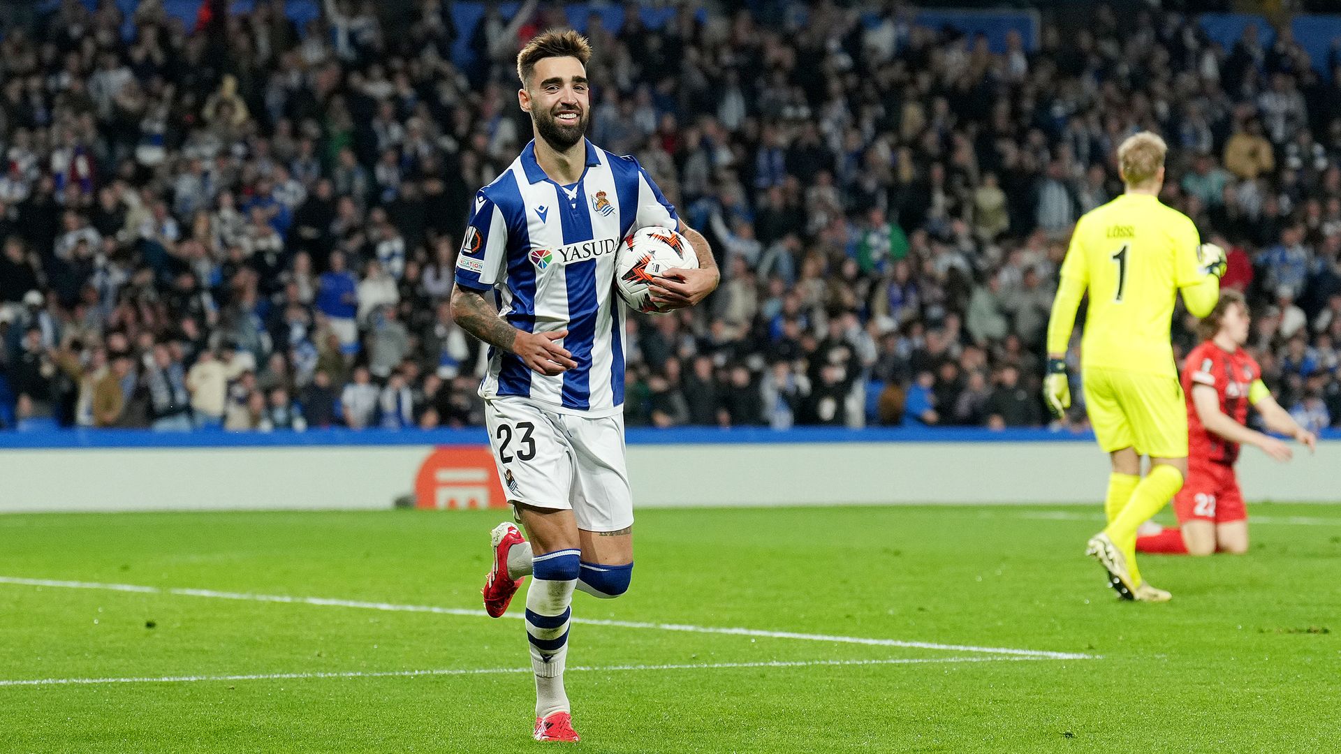 Brais Mendez celebrates scoring a goal while wearing a Real Sociedad kit