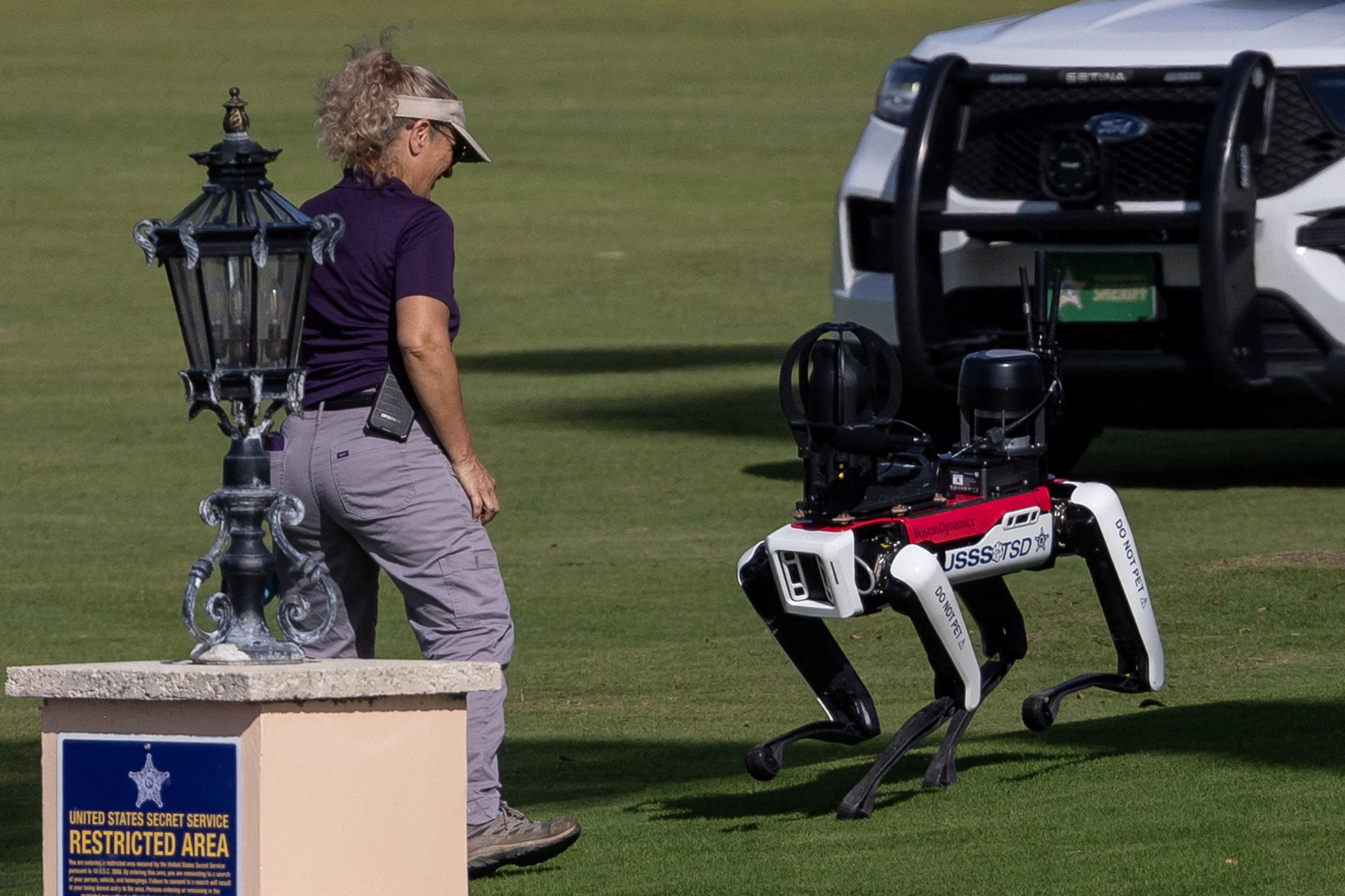 A Secret Service officer interacts with a robot dog at U.S. President-elect Donald Trump's residence at Mar-a-Lago in Palm Beach, Florida, U.S., November 12, 2024. REUTERS/Carlos Barria 