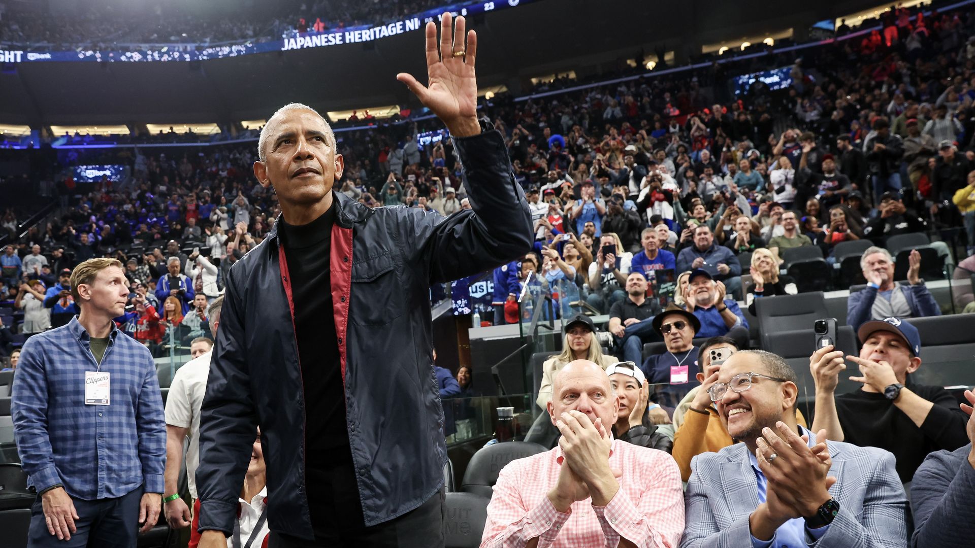 Former President Barack Obama waves to fans during the game between the LA Clippers and the Detroit Pistons 