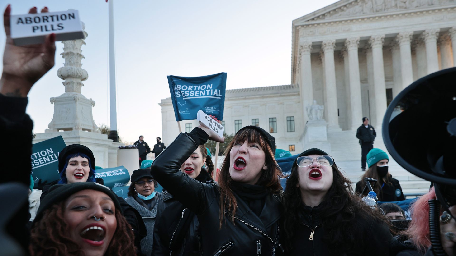 Picture of women holding boxes that say "Abortion pills"