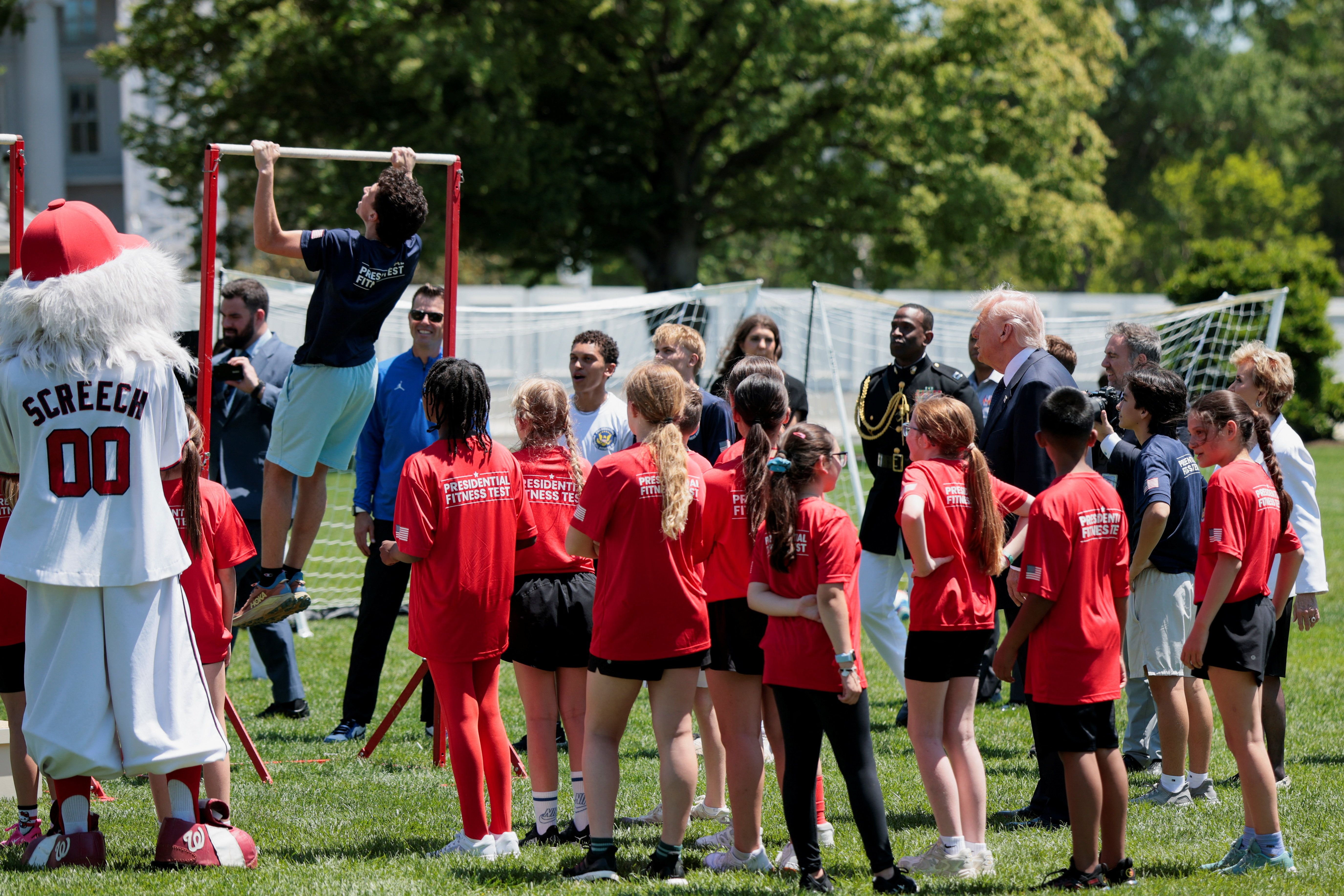 President Trump watches a fitness demonstration on the South Lawn yesterday. 