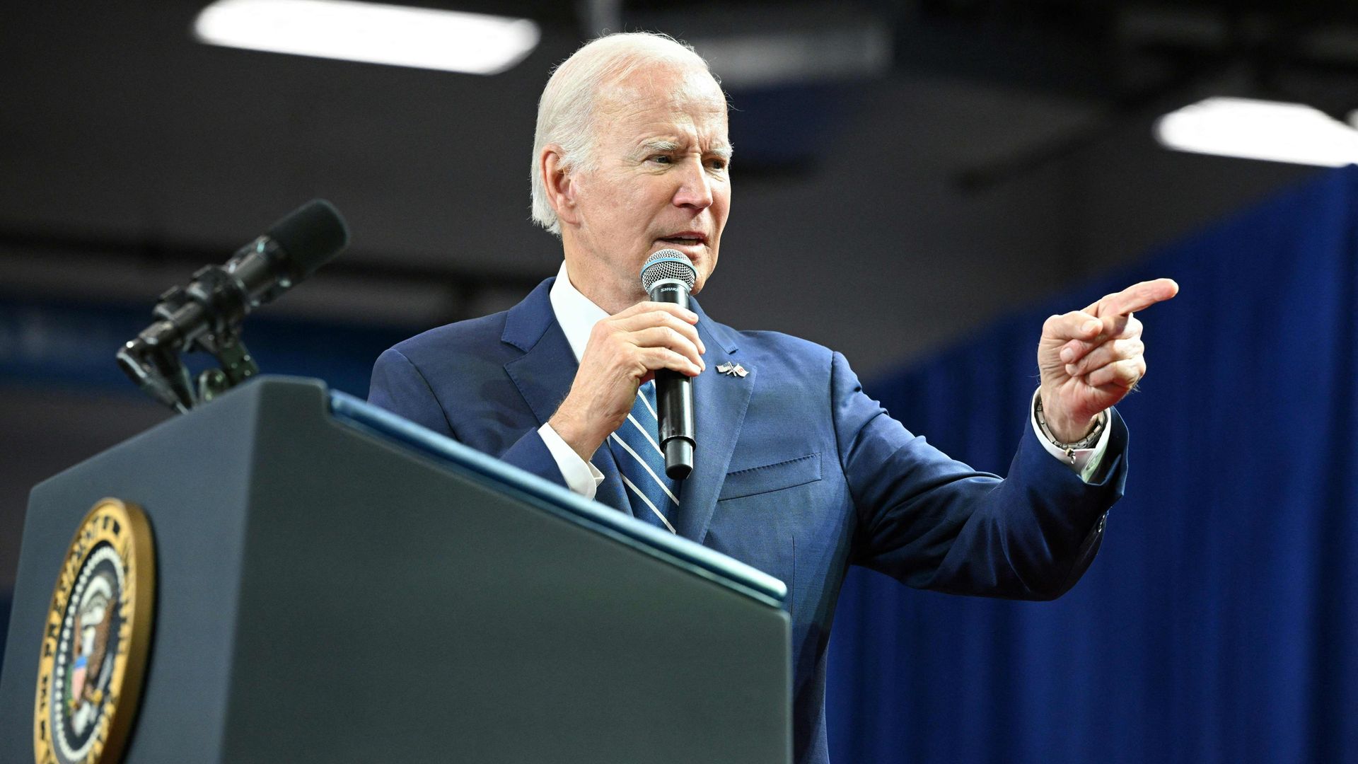 President Joe Biden speaks from a podium at an event.