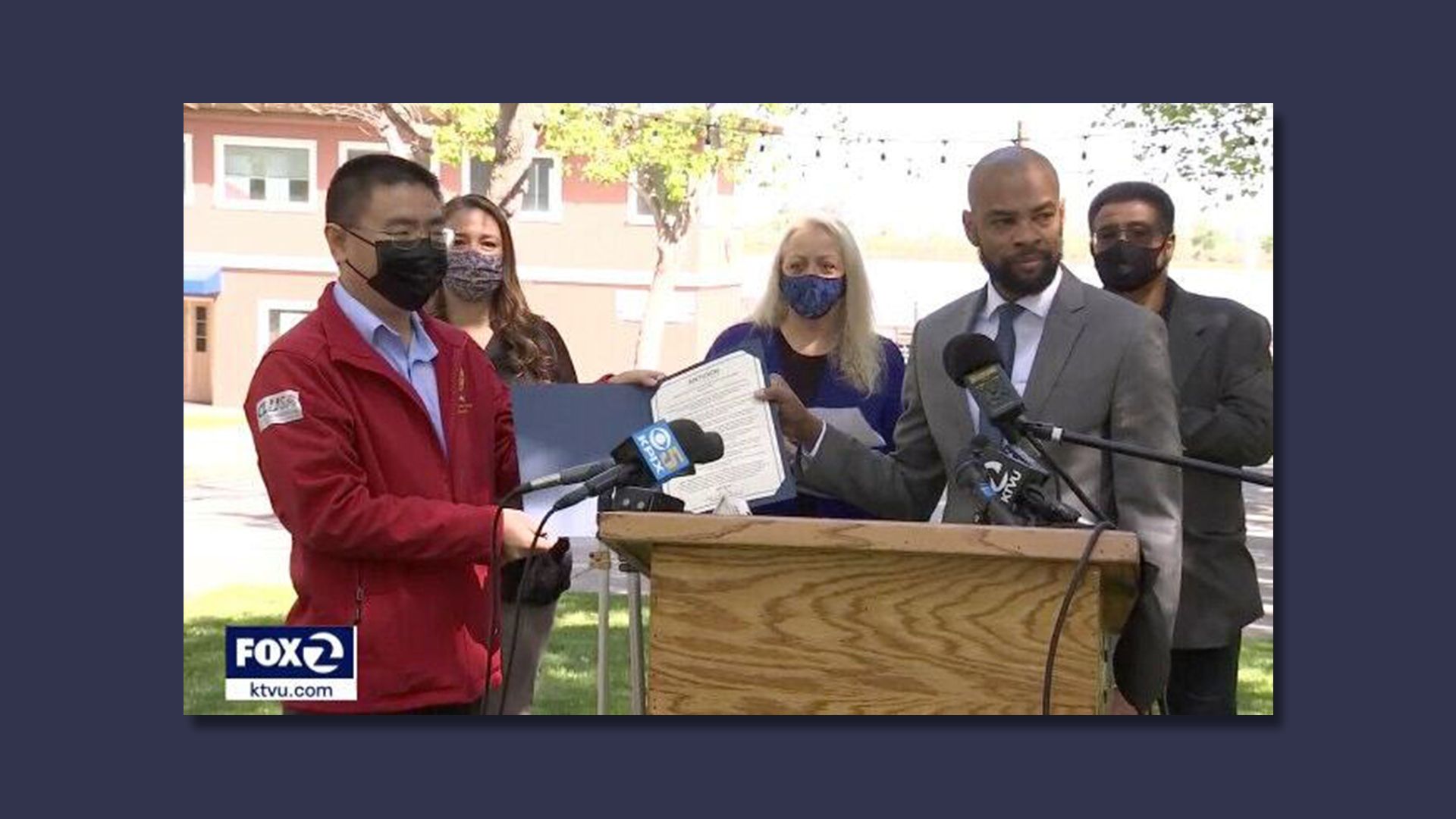 Photo of the Antioch mayor holding up a proclamation apologizing for Antioch's early treatment of Chinese residents