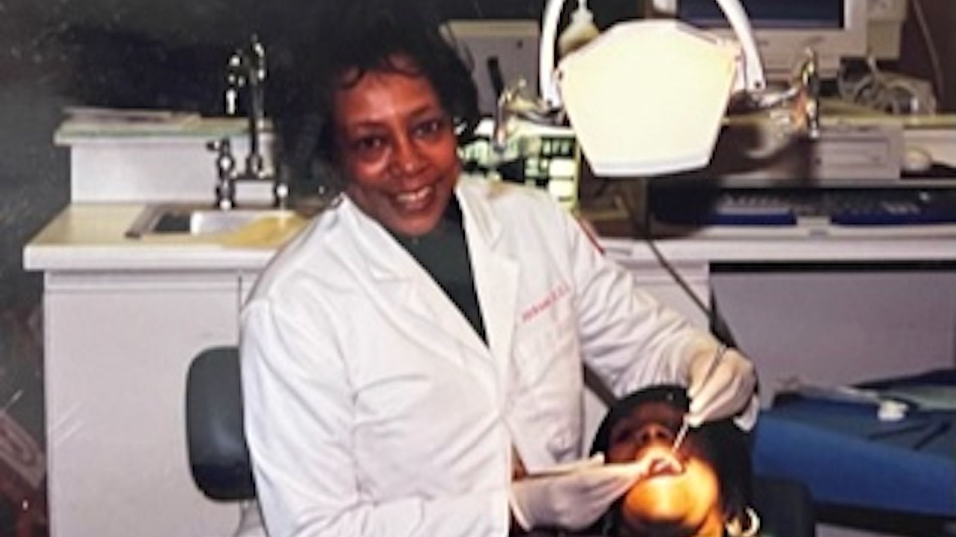 A photo of Dr. Jackson with her hands in a patient's mouth