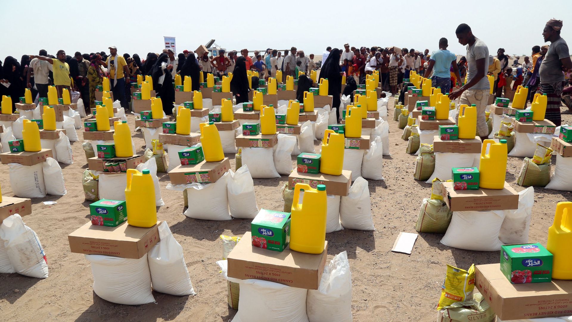 Yemenis displaced by the conflict, receive food aid and supplies to meet their basic needs, at a camp in Hays district in the war-ravaged western province of Hodeida on August 31.