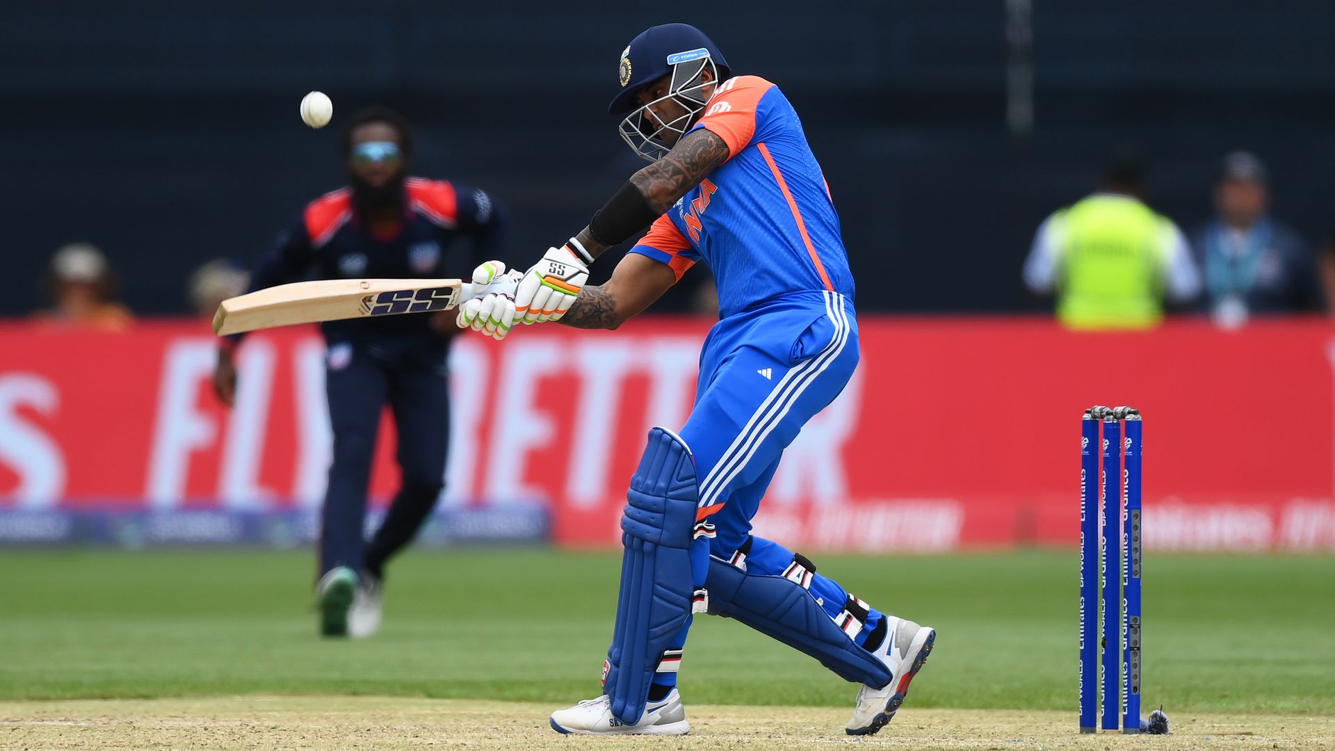 Photo of a cricket player swinging a bat on a field