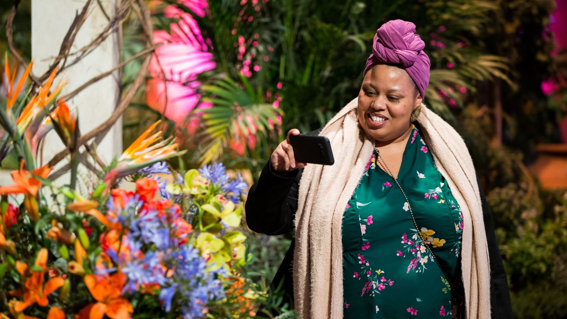 A woman snaps a photo of a floral display at the Philadelphia Flower Show.