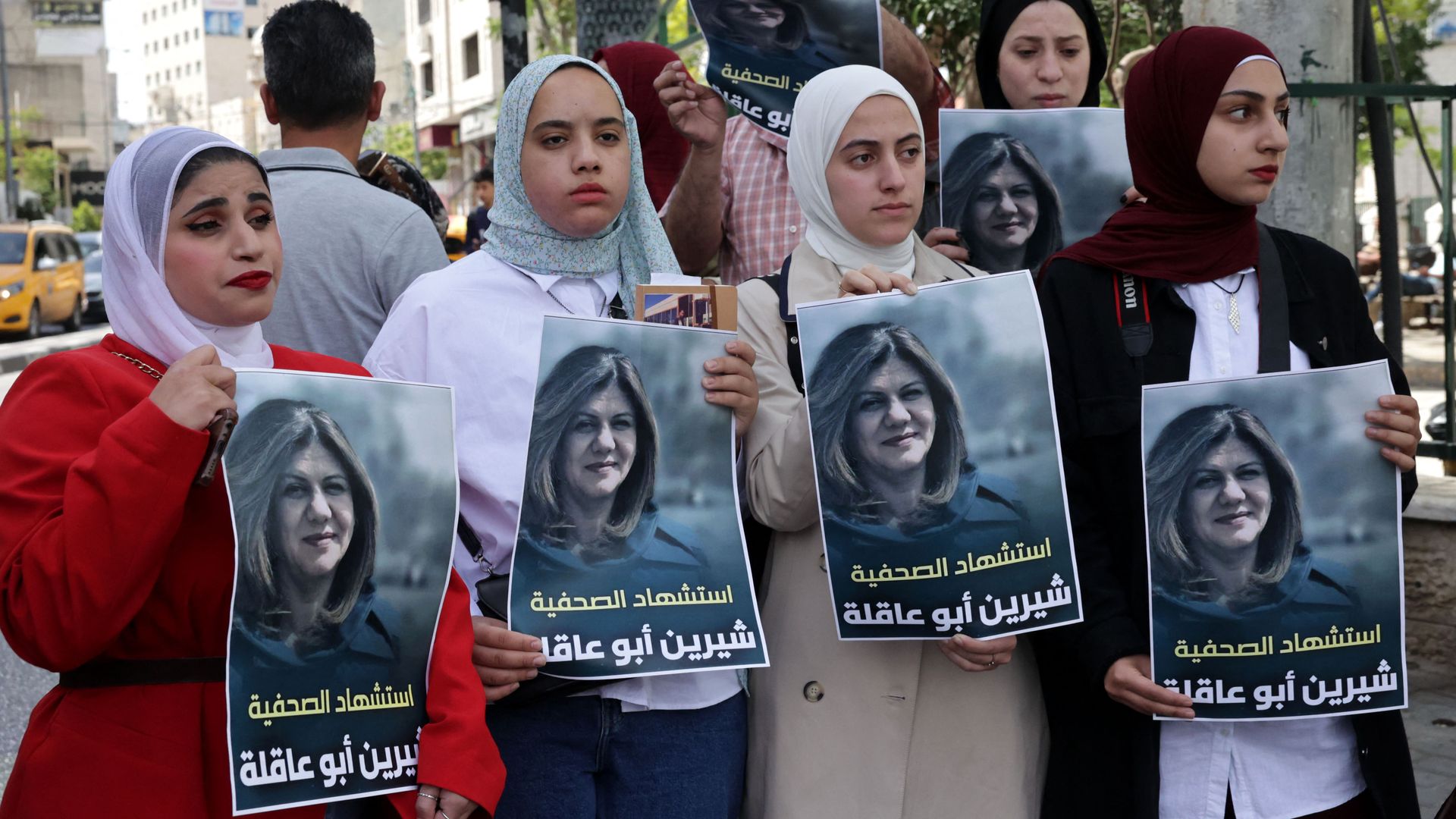 Palestinians hold posters displaying veteran Al Jazeera journalist Shireen Abu Aqleh on May 11 in Hebron. Photo: