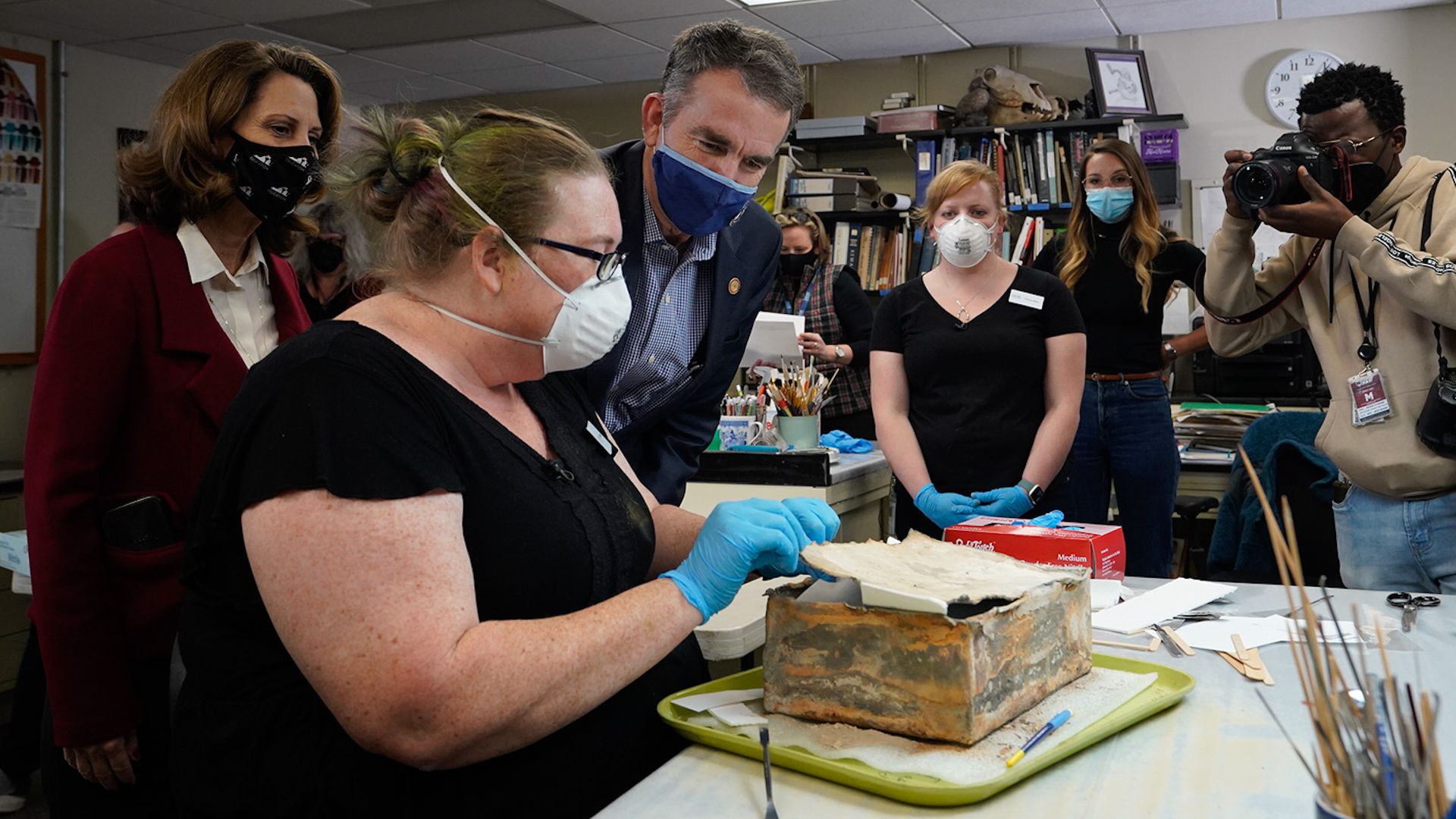 Virginia Gov. Ralph Northam (C) watches as the contents of a time capsule from the pedestal that once held the statue of Confederate General Robert E. Lee are removed.