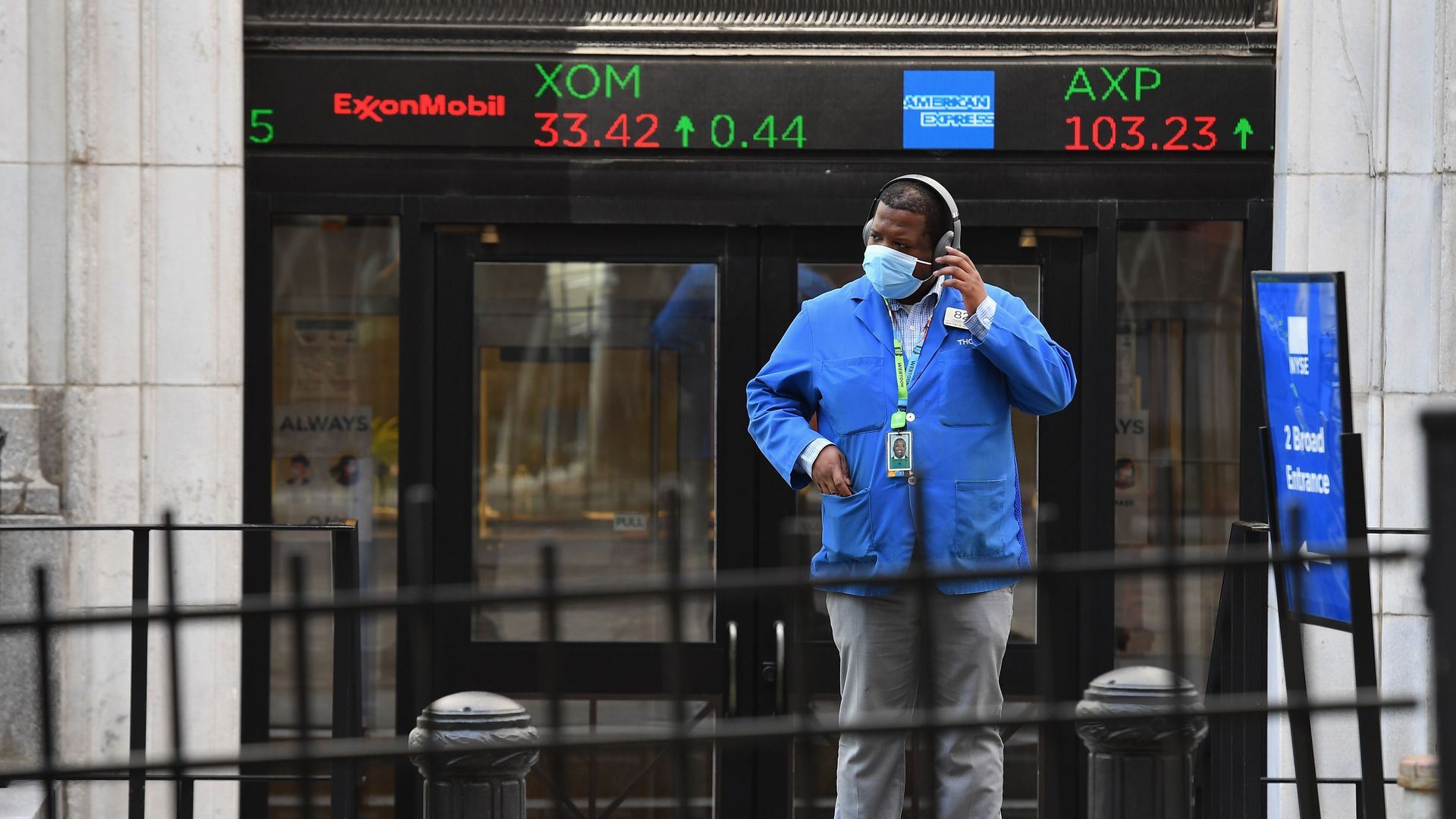 A photo of a stock trader checking his headphones outside the New York Stock Exchange (NYSE) in lower Manhattan.