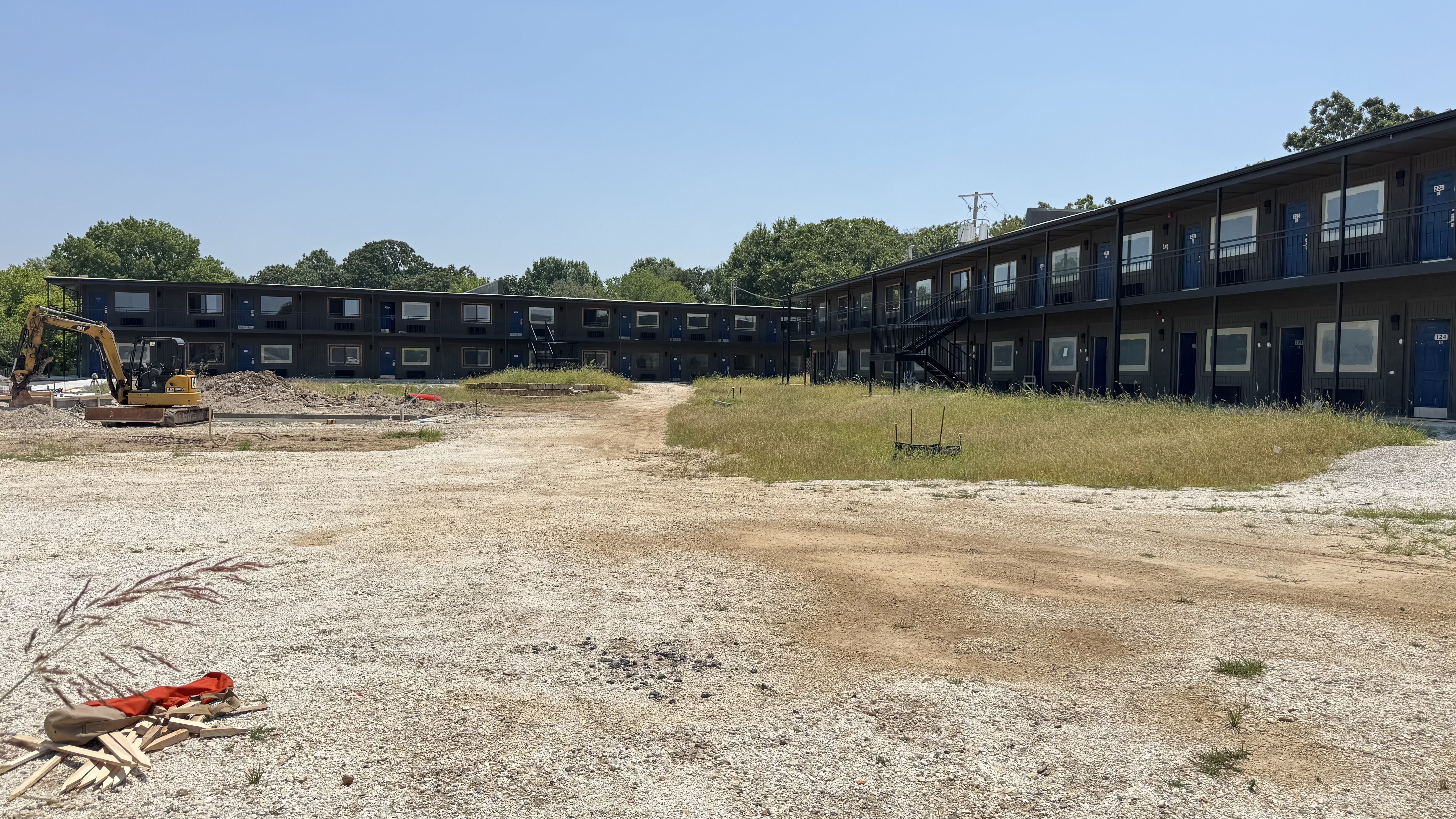 A former Motel 6 property is being renovated, with two-story motel buildings surrounding an active construction site.