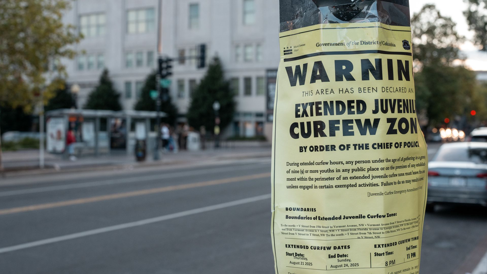 A sign on a lamp post that says "Extended Juvenile Curfew Zone" 