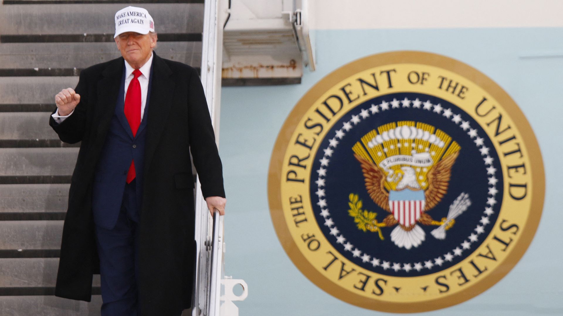 US President Donald Trump raises a fist as he steps off of Air Force One upon arrival at Calgary International Airport, before the start of the G7 summit, in Calgary, Alberta, Canada, June 15, 2025. 