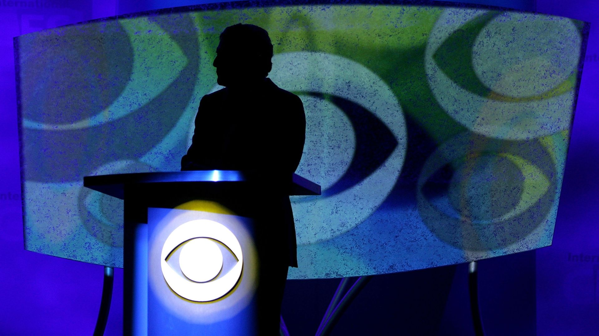 Leslie Moonves shawdowed out on the stage at a conference