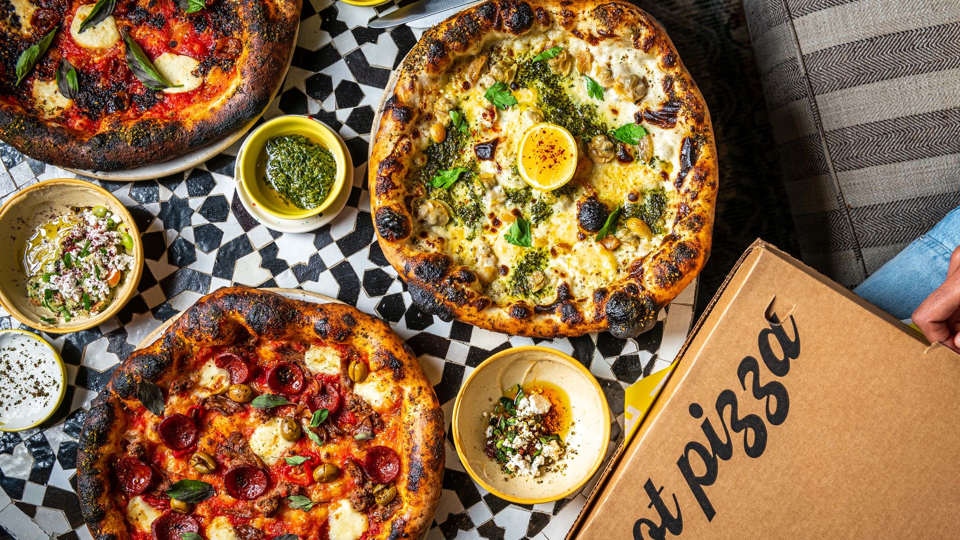 Three Mediterranean pizzas on a checkered table