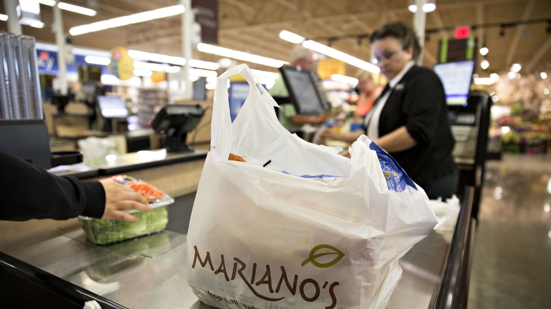 A white plastic Mariano's bag on a conveyor belt.