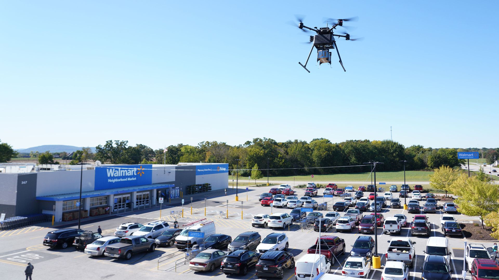 A drone flies over a Walmart parking lot.