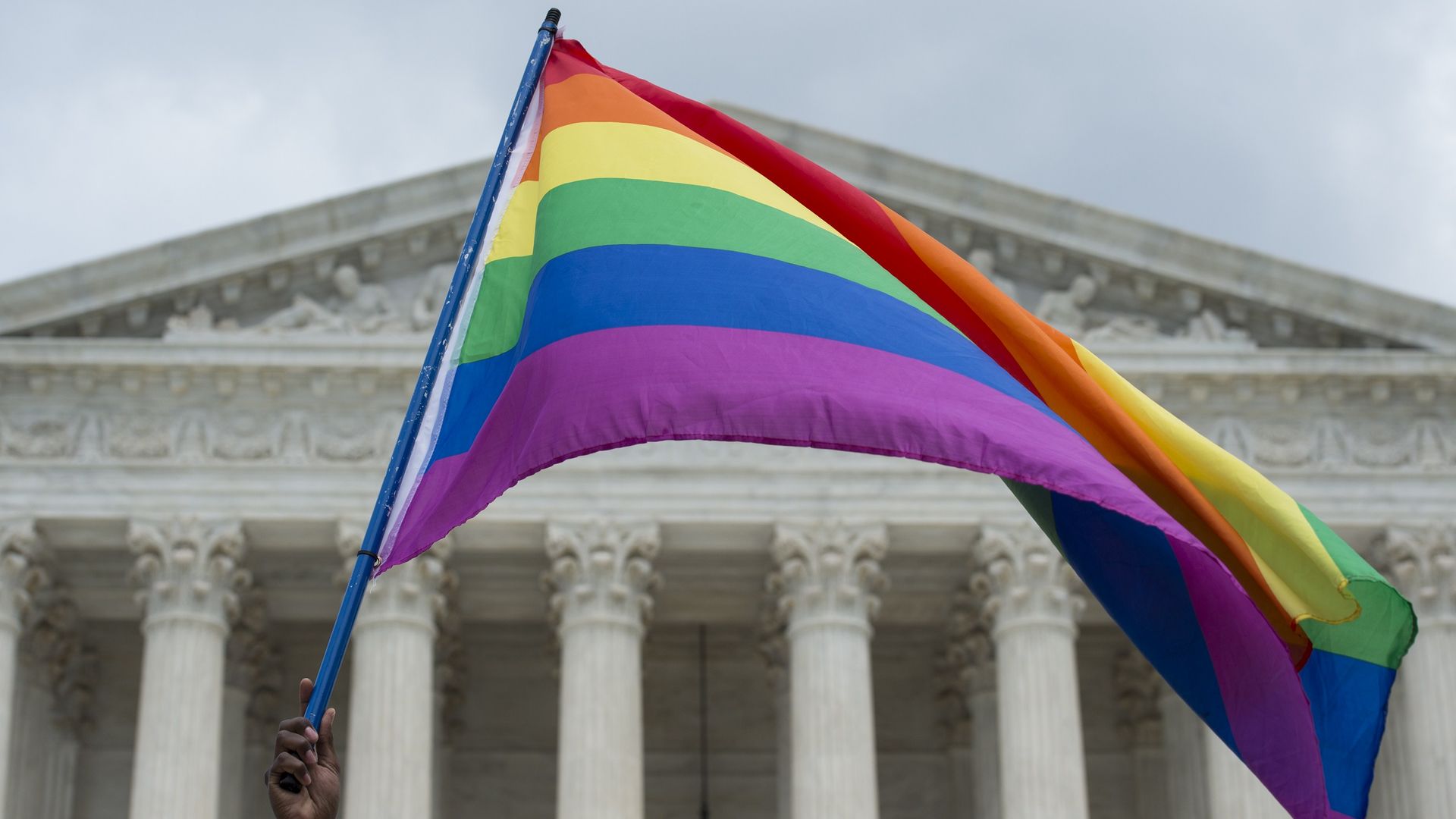 A rainbow flag flies in front of the U.S. Supreme Court.