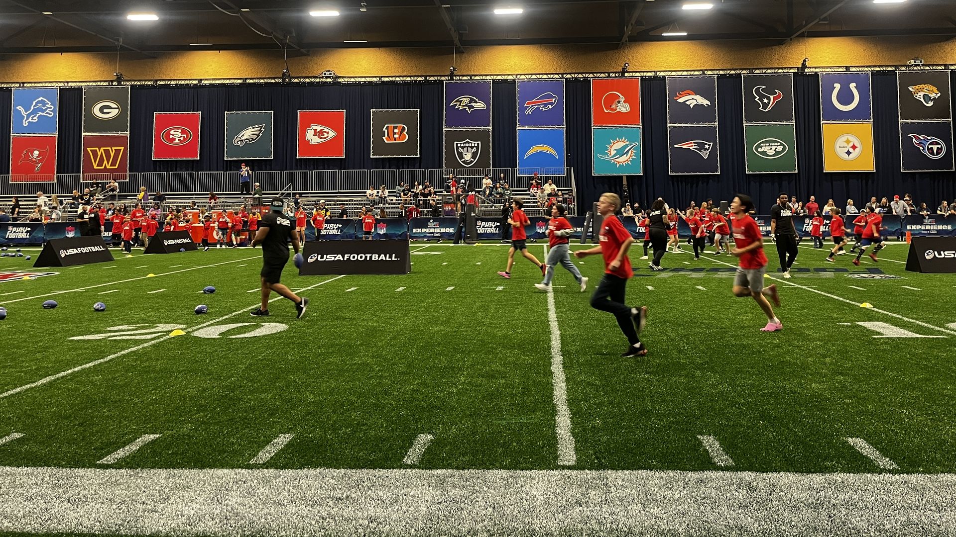 Children running on an indoor football field. 