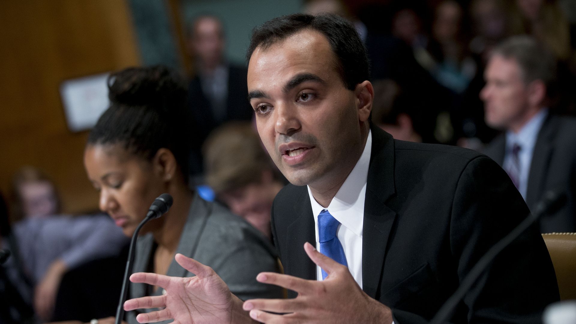 CFPB's Rohit Chopra speaking at a table.