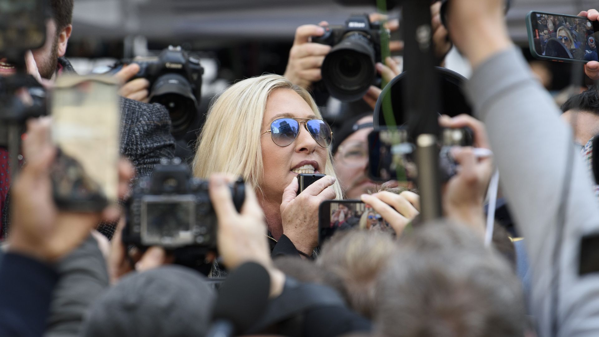 Marjorie Taylor Greene amid a crowd of media